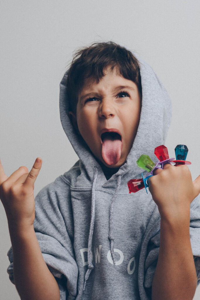 Student in a Redwood hoodie making a silly face with toy rings