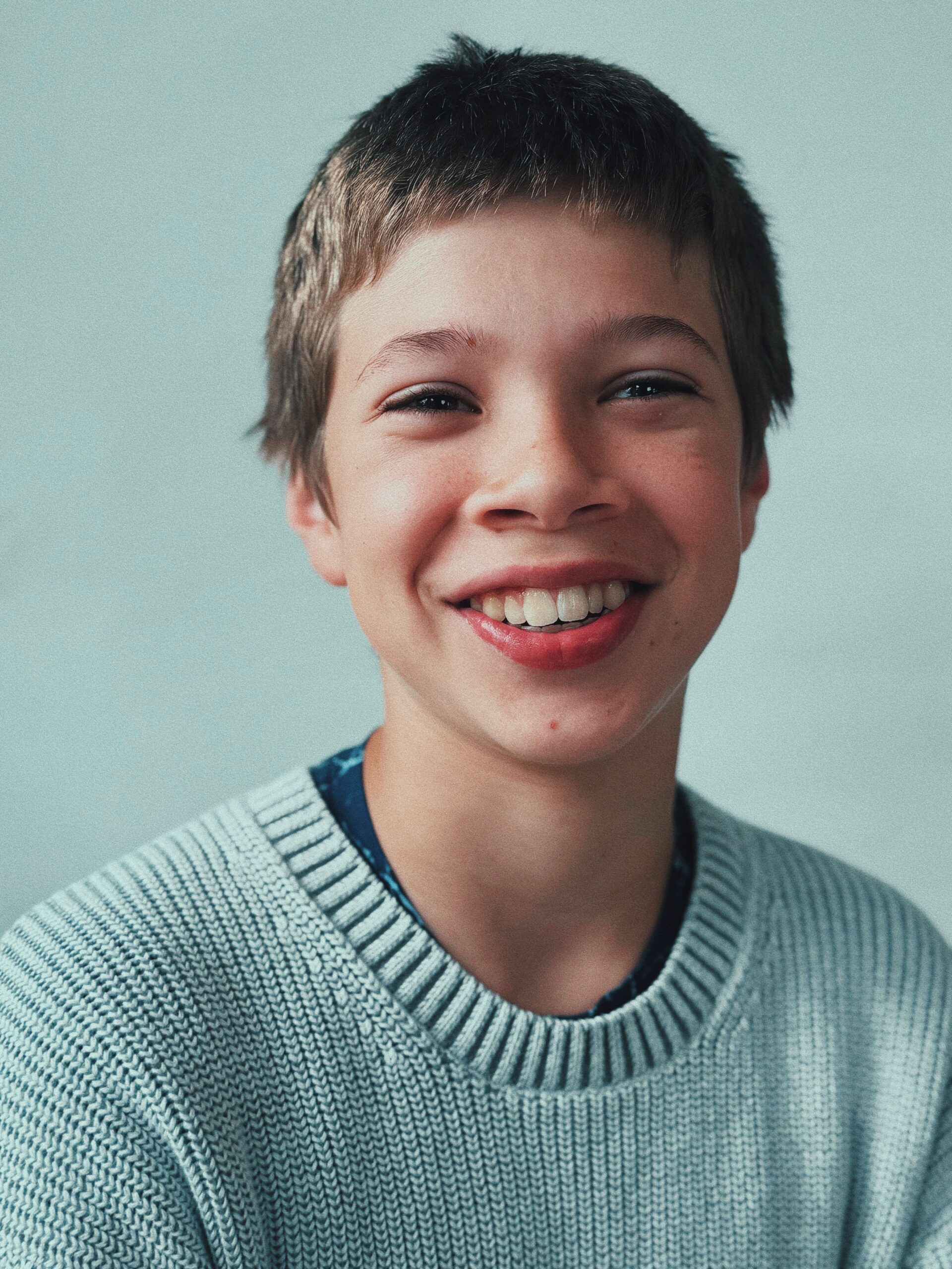 Redwood student smiling in a light sweater